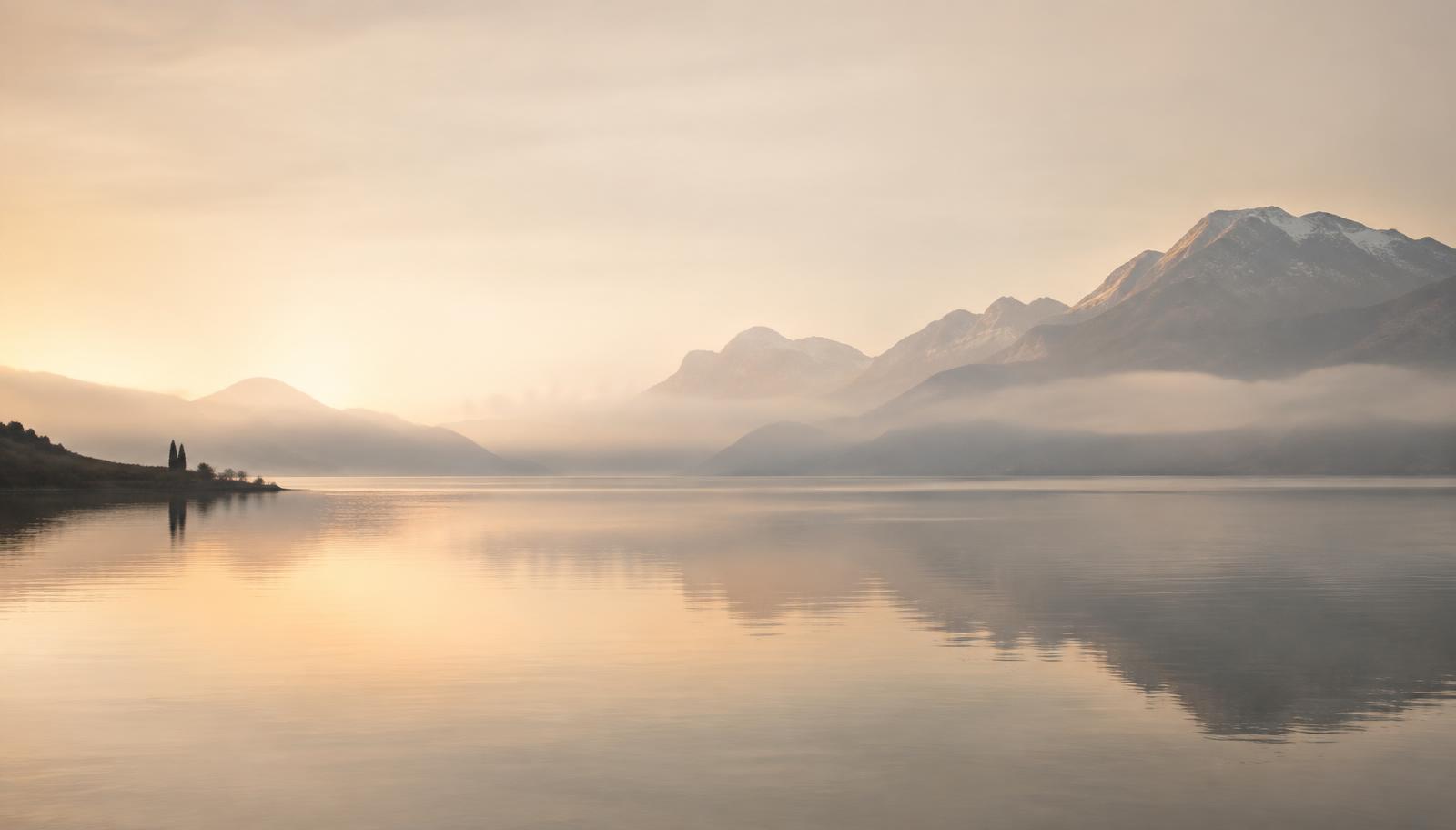 Stiller Schweizer See mit Bergen im Morgennebel